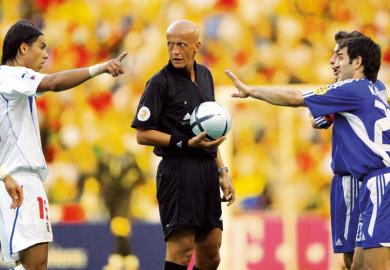 Footballers arguing with the referee in the centre to illustrate