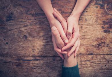 Woman holding man's hand providing support/kindness
