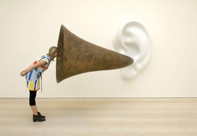 Woman looking into ear trumpet