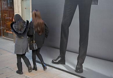 Women walking past mans legs