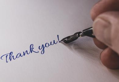 Close-up of a hand from a person writing thank you with a fountain pen