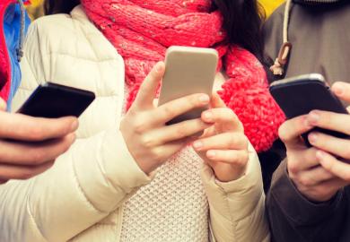 Young people gathered together using smartphones