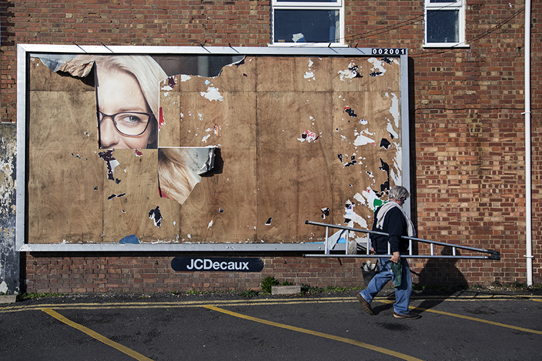 A window cleaner walks past a billboard with a small portion of an old advert remaining in London, England. To illustrate that the deteriorating finances of HE providers could hamper the sector’s ability to provide skills to the creative industries.