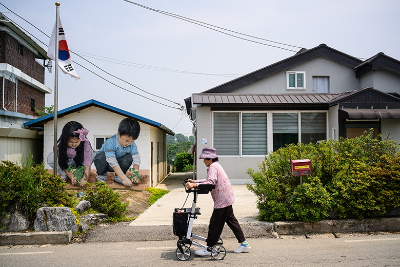 An elderly resident uses her walking frame as she walks along a street in Tongilchon, or Unification Village, on 28 May 2025, located some 60 kilometres from Seoul in the Civilian Control Zone (CCZ), a restricted area next to the more famous DMZ. An elderly resident uses her walking frame as she walks along a street in Tongilchon, or Unification Village, on 28 May 2025, located some 60 kilometres from Seoul in the Civilian Control Zone (CCZ), a restricted area next to the more famous DMZ.
