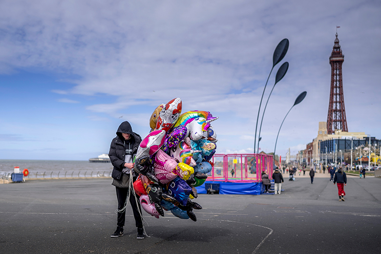 A balloon vendor with no custiomers braves the wind. To illustrate the risk that the LLE may not have much interest from students