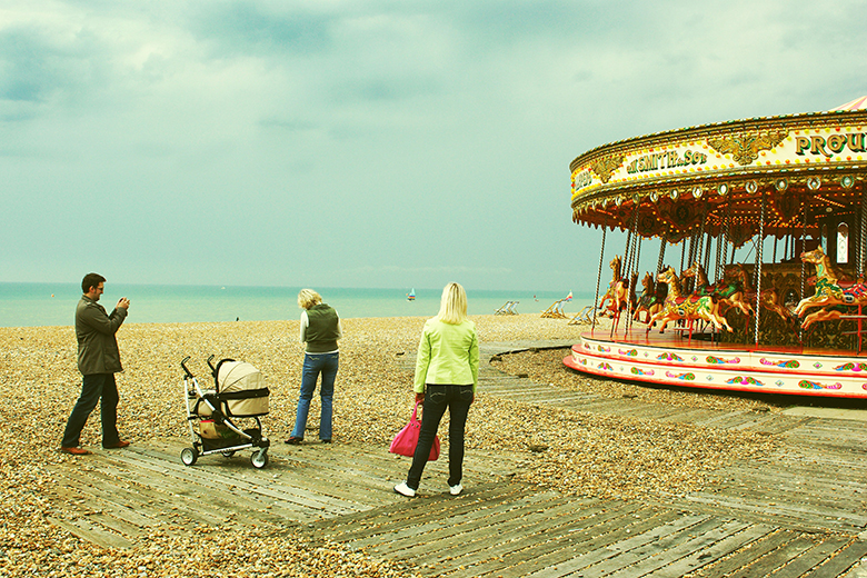 A family on a beach, unsure whether to ride a carousel. To illustrate uncertainty about what regulation could look like in the future for LLE.