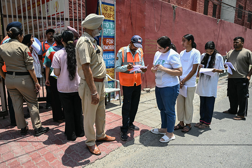 Security personnel check documents of medical students before the National Eligibility-cum-Entrance Test (NEET-UG) re-examination in Amritsar on 21 June 2026.