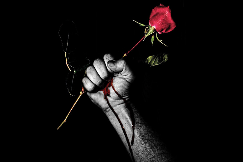 Hand gripping a rose