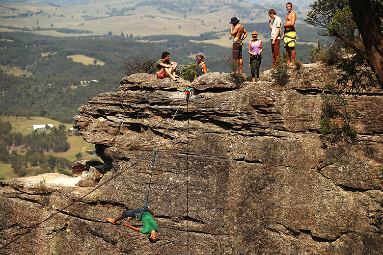 A man swings by his safety harness after falling from a highline rigged between cliffs at Corroboree Walls in Mount Victoria, Australia. To illustrate the gap in salaries between academics and specialists.