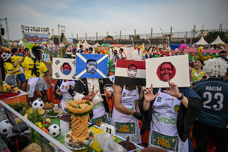 Participants dressed in football team national flags dance before preparing rujak uleg, a traditional Indonesian savoury salad to welcome the upcoming 2026 FIFA World Cup, in Surabaya on 9 May 2026. To illustrate internationalisation targets.