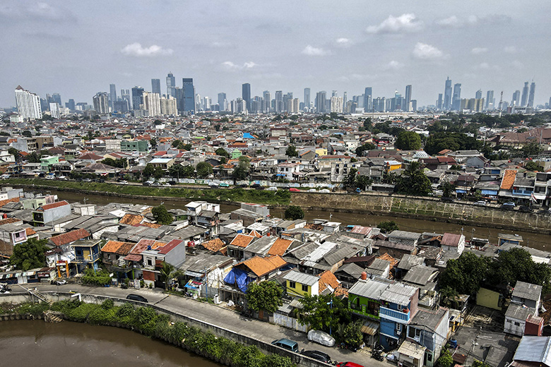 Aerial picture showing housing before the skyline of the Jakarta business district on 9 May 2025.