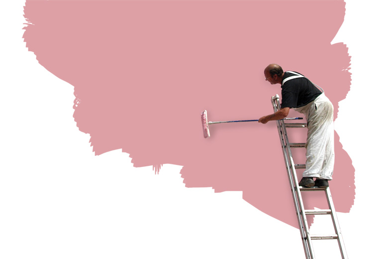 Man on ladder painting wall