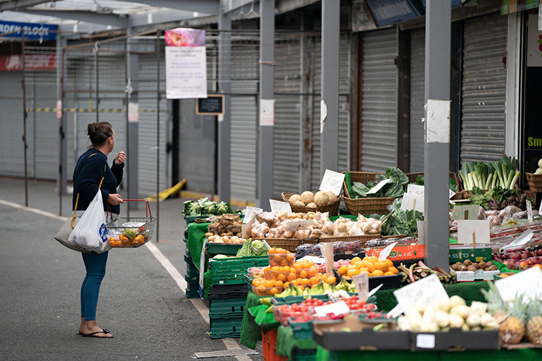 A customer at a fruit and vegetable stall, with boarded-up market stalls in the background. To illustrate that some providers such as high-tariff universities are unlikely to want to join the market for LLE.
