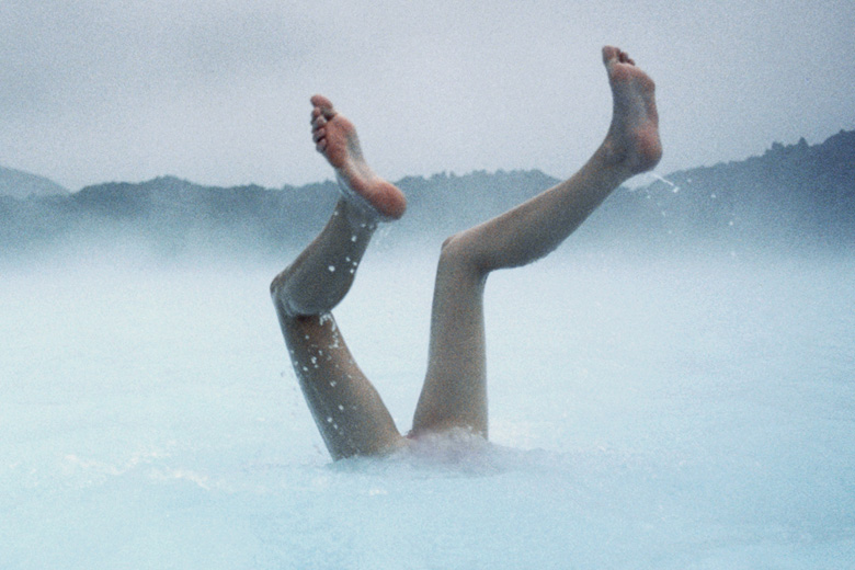 Person's legs protruding from water, Blue Lagoon, Reykjanes Peninsula, Iceland
