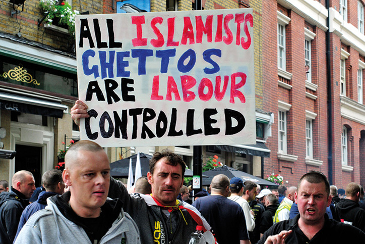 Protesters holding 'All Islamists ghettos are Labour controlled' placard