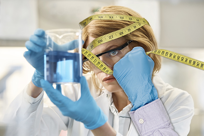 A hand pulling away measuring tape from a young scientist's face. To illustrate that the present system of using metrics is not inevitable or beyond challenge. A hand pulling away measuring tape from a young scientist's face. To illustrate that the present system of using metrics is not inevitable or beyond challenge.