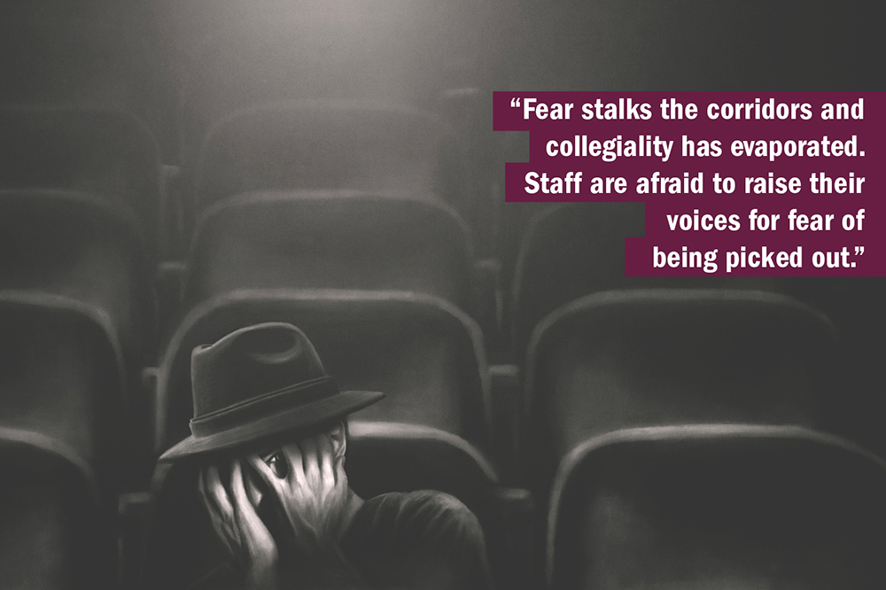 THE UK University Redundancy Survey. Person cowering in fear in lecture hall.