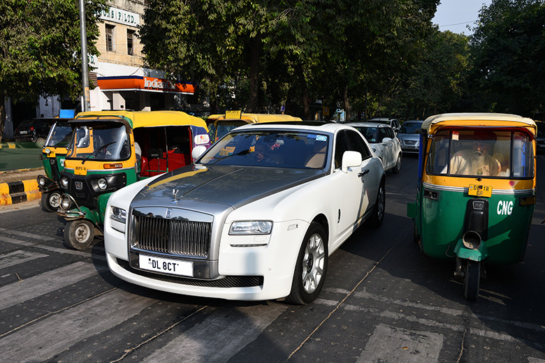 A Rolls-Royce car alongside auto-rickshaws in a residential area in Delhi, India. To illustrate the difference in fees charged by the international branch campuses compared with Indian institutions. A Rolls-Royce car alongside auto-rickshaws in a residential area in Delhi, India. To illustrate the difference in fees charged by the international branch campuses compared with Indian institutions.