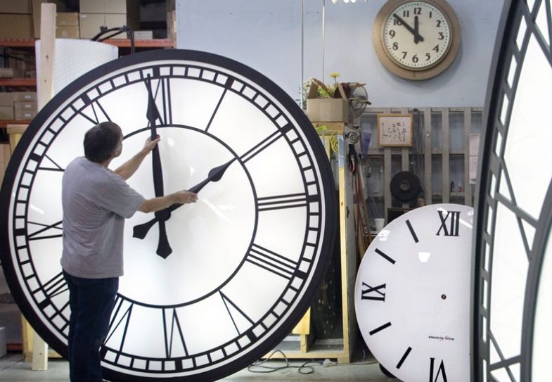 A worker at Electric Time adjusts the hands on a clock to illustrate Timetabling my life