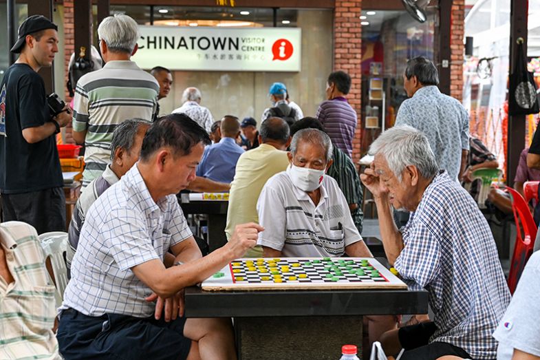 Elderly people play checkers in Singapore’s Chinatown. To illustrate the ageing population of Singapore.