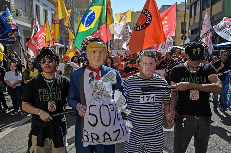 Protesters wearing masks depicting US president Donald Trump and former Brazilian president Jair Bolsonaro take part in a demonstration in downtown São Paulo, Brazil on 18 July 2025. 
