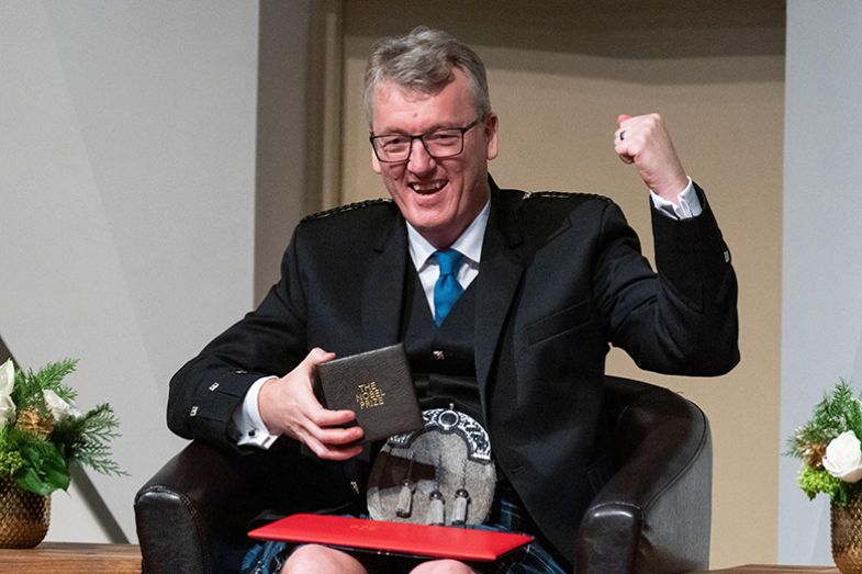 David MacMillan celebrates with his Nobel Prize in Chemistry during a ceremonial presentation at the National Academy of Sciences, 6 December 2021, in Washington, DC.