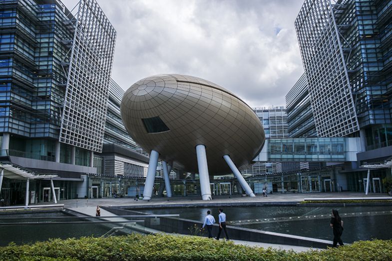 People walk along a pedestrian bridge in front of the Charles K. Kao Auditorium, centre, in the Hong Kong Science Park. The hub is the city’s biggest existing technology park.