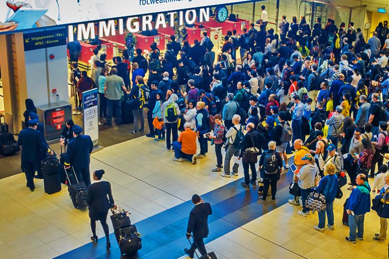 High-angle view of a crowd of people in arrivals immigration queue at Changi airport, Singapore, with a separate entrance for Singaporeans