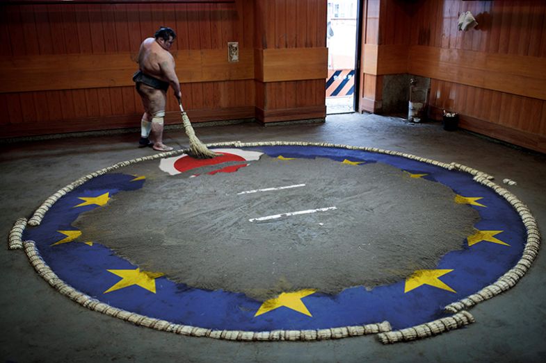 Sumo wrestler sweeping the ring to expose a Japanese flag among the stars of the EU flag. To illustrate Japan participating in Horizon Europe, but needing to be mindful of Japanese priorities. Sumo wrestler sweeping the ring to expose a Japanese flag among the stars of the EU flag. To illustrate Japan participating in Horizon Europe, but needing to be mindful of Japanese priorities.