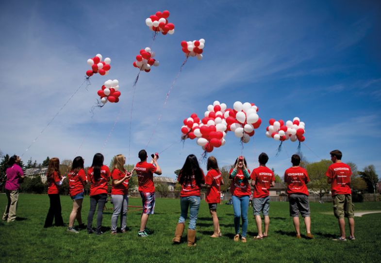 Students release a thousand biodegradable helium balloons and flying them as kites to create create a happy, supportive environment in Toronto