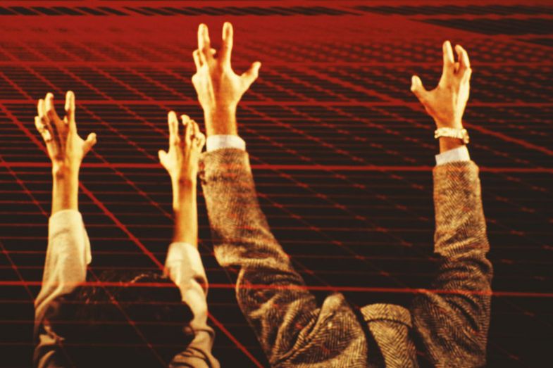 A man and a woman stretch out their arms toward a red computerised grid