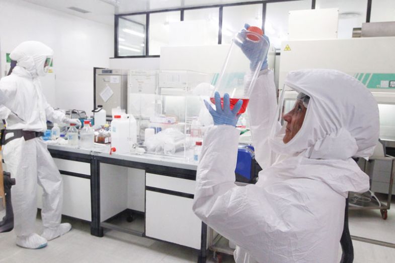 A bacteriologist wears protective suit performs the analysis of a Coronavirus test in the High Security Laboratory  to show the measures needed for high security