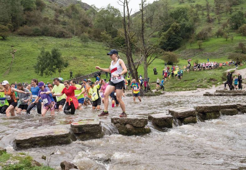 Competitors running in theatre and on stepping stones in the Dovedale Dash to illustrate Buoying people up