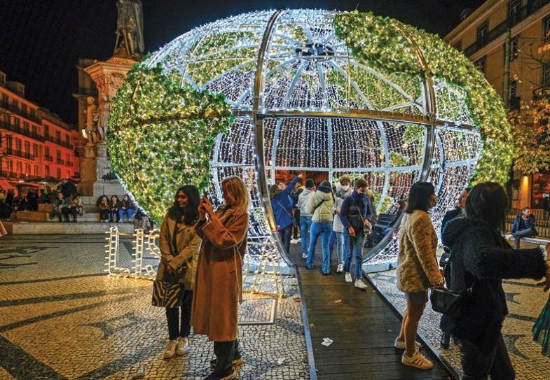ople walk inside of the lit globe representing the planet, part of Christmas and New Year illuminations, to illustrate the global village
