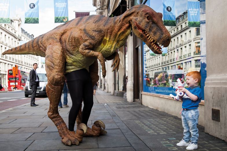 Tristan Robertson-Jeyes, aged 3, plays with a 'Teksta T-Rex' toy dinosaur outside Hamley's toy shop 