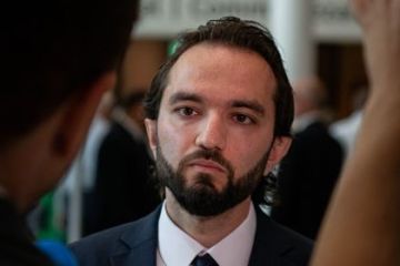 Iranian student Armin, who has dark hair and is wearing a suit and tie, looking to his right