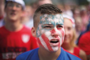 Young man with American flag painted on face Young man with American flag painted on face
