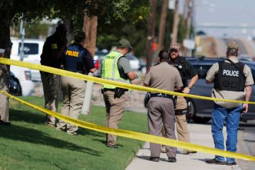 A law enforcement officer stands in the middle of the 5100 block of E. 42nd Street in Odessa, Texas, Saturday, Aug. 31, 2019, following a shooting at random in the area of Odessa and Midland. Several people were dead after a gunman who hijacked a postal s