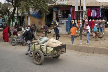 A porter pushing a cart full of parcels in the main street of Arusha, Tanzania A porter pushing a cart full of parcels in the main street of Arusha, Tanzania