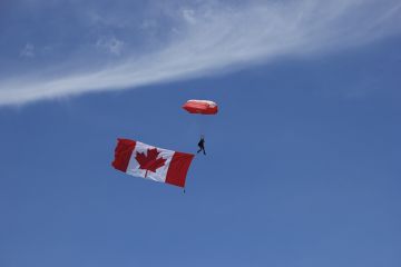 A Skyhawk team member is seen in the image with the flag of Canada, “The Maple Leaf” in tow at the beginning of the performance at the 2016 Duluth Air Show