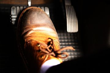 A foot pushes a car's brake pedal A foot pushes a car's brake pedal