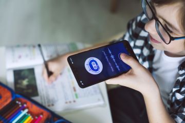 Someone holding their phone to their mouth, talking into an AI chatbot