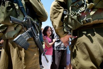 Al-Walaja, Occupied Palestinian Territories - August 27, 2011 A Palestinian girl confronts Israeli soldiers in a protest against the encirclement of the West Bank town of Al-Walaja by the Israeli separation barrier.
