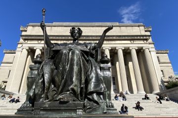 Alma Mater statue by Daniel Chester French in front of students sitting on the Low Library steps on Columbia University's main campus