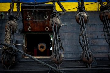 Antique cannon pointing out of hatch of old warship Antique cannon pointing out of hatch of old warship