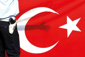 Armed guard standing in front of flag of Turkey Armed guard standing in front of flag of Turkey