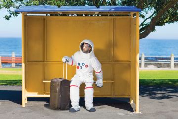 Astronaut waiting with suitcase at bus stop Astronaut waiting with suitcase at bus stop