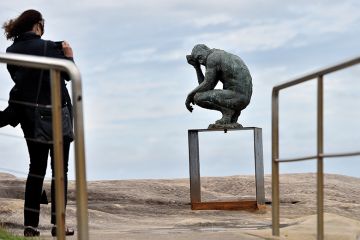 A visitor takes a picture of a sculpture by British artist Laurence Edwards at the “Sculpture by the Sea” exhibition that runs along the Bondi to Tamarama coastal walk in Sydney, 22 October 2015 A visitor takes a picture of a sculpture by British artist Laurence Edwards at the “Sculpture by the Sea” exhibition that runs along the Bondi to Tamarama coastal walk in Sydney, 22 October 2015