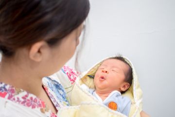 Baby carried by mother illustrating how work-life balance influences gender disparity in science