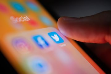Bangkok, Thailand - July 14, 2019  iPhone user touching Twitter logo on iPhone screen to open the app.